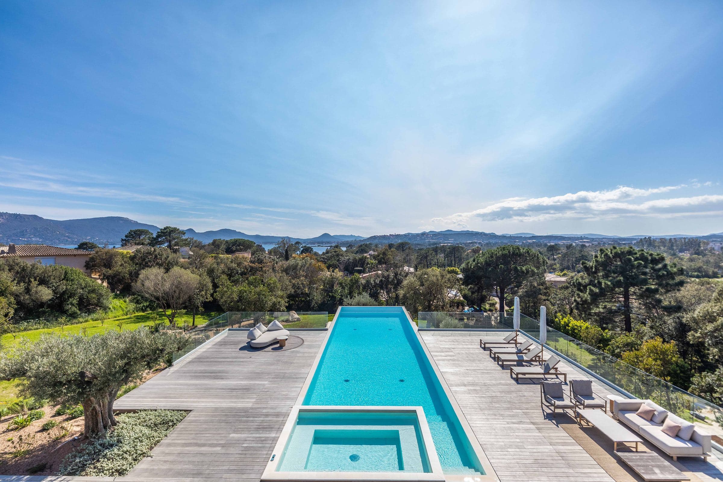 The pool and its jacuzzi seen from the upper terrace, gulf beyond